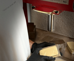 Pesée artisanale du hash CBD dans l'atelier La Plaquette en Suisse